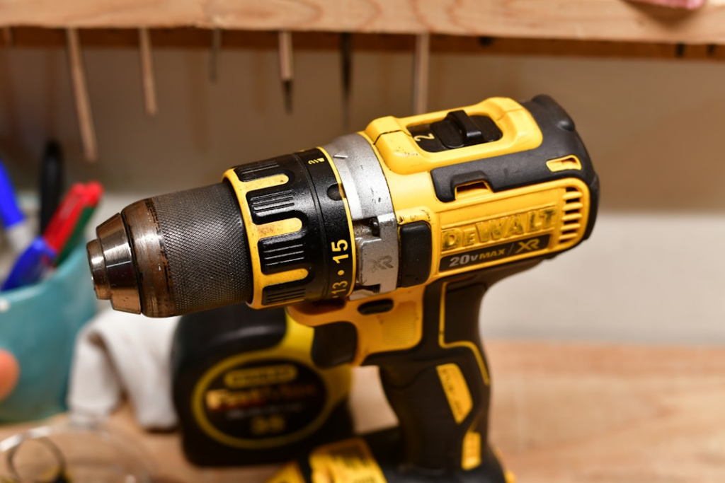 A dewalt impact driver with tape measure in the background.source - https://unsplash.com/photos/yellow-and-black-cordless-power-drill-on-a-workbench-QvEXI1xquRY