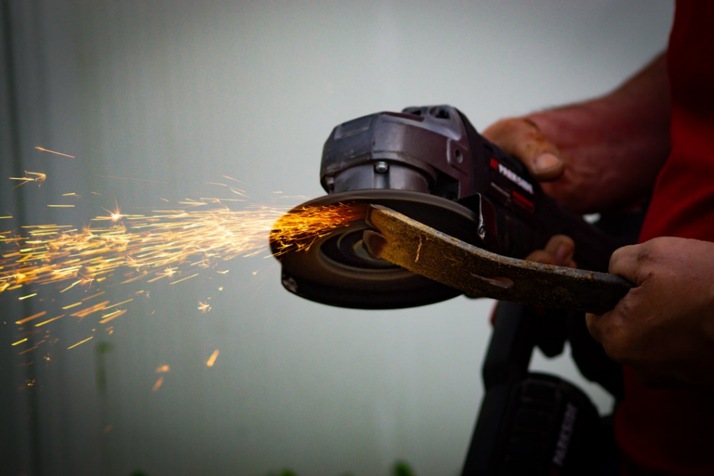 Person repairing a crowbar using an anglegrindersource - https://unsplash.com/photos/a-person-using-a-grinder-on-a-piece-of-wood-B3kl6W9pKyQ