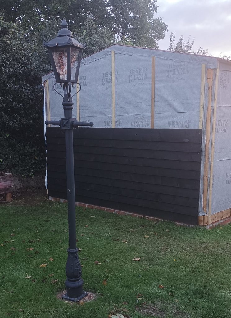 The end of the workshopshed with the first 10 planks nailed in place. Behind the planks you can see the waterproof membrane and some vertical battens.